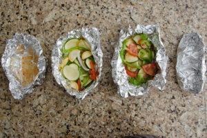 a group of vegetables in foil packets