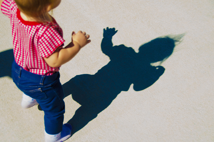 a child standing in front of its shadow