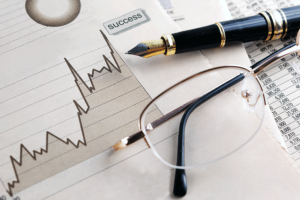 a report comparing index funds and etfs plus a pen and glasses