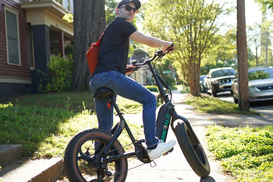 Man riding Emerald electric bike through neighborhood